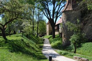 a path in a park with trees and a building at Ferienwohnung Veste Coburg in Bad Rodach