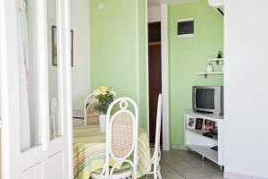 a room with green walls and a chair and a tv at Villa Sarah in Selca