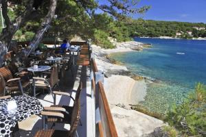 een terras met tafels en stoelen en een strand bij Villa Sarah in Selca