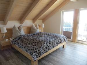 uma cama grande num quarto com uma janela grande em Ferienwohnung bei Maly em Sulzberg
