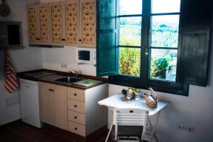 kuchnia ze stołem, umywalką i oknem w obiekcie FINCA LA PLANTACIÓN _Agroturismo w mieście La Orotava