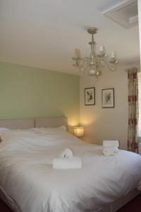 a bedroom with a white bed with two towels on it at Ebberley Escapes in Great Torrington