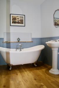 a bath tub and a sink in a bathroom at Ebberley Escapes in Great Torrington