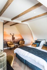 a bedroom with two beds and a painting of a deer at de Vogelensangh in Vogelenzang