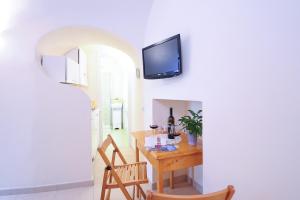 a dining room with a table and a tv on a wall at Alfieri Rooms - Luna - Amalfi Coast in Atrani