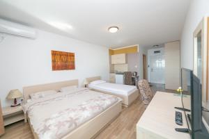 - une chambre avec un grand lit et un bureau dans l'établissement Apartments Marija, à Sveti Stefan
