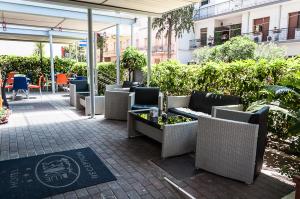 een patio met rieten stoelen en tafels in een gebouw bij B & B Appia Antica in Mesagne