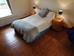 um quarto com uma cama grande e piso em madeira em Tig Rua em Killarney