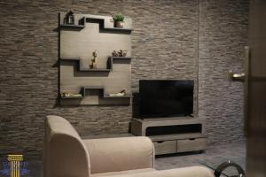 ベイルートにあるGrand Suites Hotelのレンガの壁、テレビ付きのリビングルーム