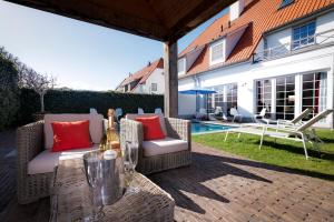 a patio with two wicker chairs and a table at B&B Maison seki in Knokke-Heist