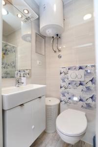 a white bathroom with a toilet and a sink at Apartment Ivan in Kastel Sucurac