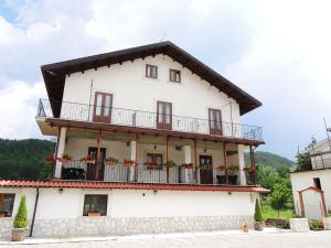 um grande edifício branco com uma varanda em Albergo del Sangro em Pescasseroli