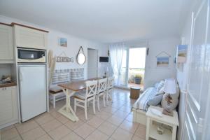 una cucina e un soggiorno con tavolo e sedie di APPT T3 Rêve d'Océan les pieds dans l'eau a Lacanau