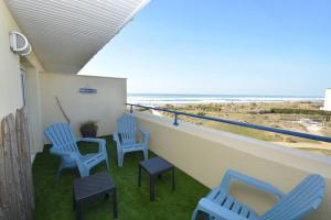 a balcony with blue chairs and a view of the beach at APPT T3 Rêve d'Océan les pieds dans l'eau in Lacanau
