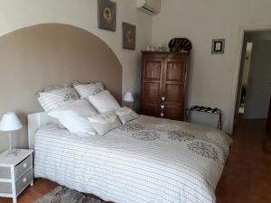 a bedroom with a large bed with white sheets and pillows at La Colombe in Tourrettes