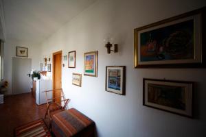 a living room with a white wall with pictures on it at B&B SoleLuna in Pisa