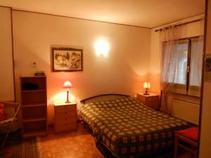 Sauze di CesanaにあるNel Borgo Incantatoのベッドルーム1室(ベッド1台、ランプ2つ、窓付)