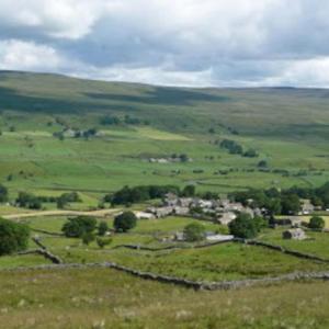a view of a green field with houses and trees at Middlegate Cottage in Hawes
