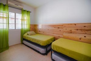 zwei Betten in einem Zimmer mit grünen Vorhängen in der Unterkunft Memorable Holidays With Your Family in Maspalomas
