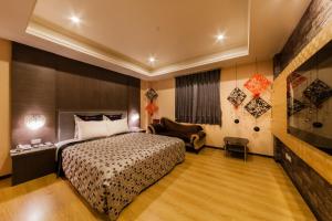 Habitación de hotel con cama y silla en QK Motel, en Taoyuan