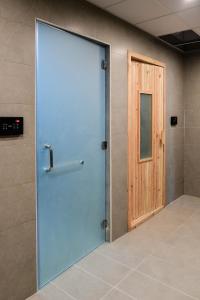 麥納麥的住宿－Noor Amwaj Hotel & Apartment，一间铺有瓷砖地板的客房内的大扇蓝色门
