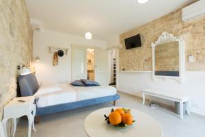 Un dormitorio con una cama y una mesa con fruta. en Evoca en Ragusa