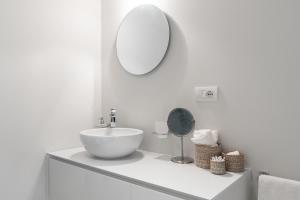 uma casa de banho branca com um lavatório e um espelho em Mini loft Moscova em Milão