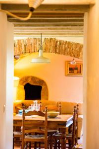 a dining room with a table and a fireplace at Can Margarit in Calonge