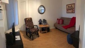 a living room with a couch and a chair at La petite maison sur la côte in Sainte-Anne-des-Monts