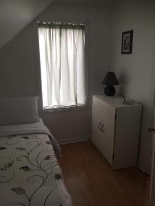 a bedroom with a bed and a window at La petite maison sur la côte in Sainte-Anne-des-Monts