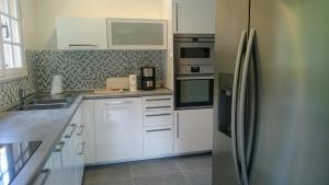 サン・ラファエルにあるla Pequenitaのキッチン(白いキャビネット、ステンレス製の冷蔵庫付)