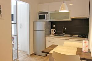 a kitchen with a table and a stainless steel refrigerator at Alison Apartments in Premantura