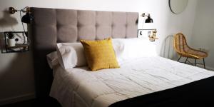 Un dormitorio con una cama grande con una almohada amarilla. en ALMAALQUILER Clavería 11, en Almagro