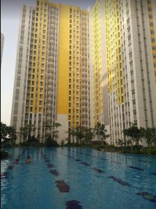 a swimming pool in front of tall buildings at Apartemen Springlake Summarecon Bekasi-By Bu Johan in Bekasi
