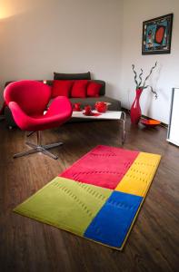 a living room with a red couch and a colorful rug at Ferienwohnung Christine in Thale