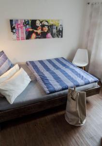 Bett in einem Zimmer mit einer Tasche auf dem Boden in der Unterkunft Ferienwohnung Christine in Thale