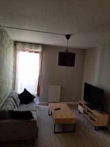 a living room with a couch and a tv at Appartement de 2 chambres au Centre de Cergy in Cergy