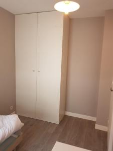 a bedroom with a bed and a white cabinet at Appartement de 2 chambres au Centre de Cergy in Cergy