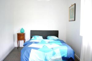 a bedroom with a blue and white bed and a table at Gîte la Providence in Saint-Sernin-du-Plain +33 photos