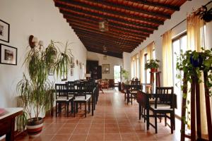 a dining room with chairs and tables and windows at Monte do Papa Leguas in Zambujeira do Mar