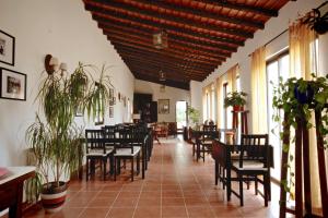 uma sala de jantar com cadeiras, mesas e janelas em Monte do Papa Leguas na Zambujeira do Mar