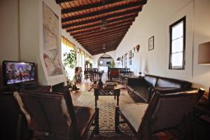 uma sala de estar com sofás, uma mesa e cadeiras em Monte do Papa Leguas na Zambujeira do Mar