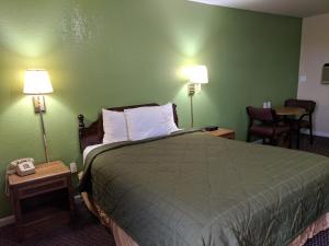 a hotel room with a bed with green walls at Benton Inn in Benton