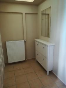 a bathroom with a white dresser and a mirror at Serifos Palace in Livadakia