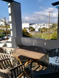 a wooden table and two chairs on a balcony at Serifos Palace in Livadakia