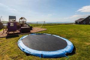 un trampoline vide dans un champ avec une aire de jeux dans l'établissement Ocean View,Kinsale, Exquisite holiday homes, sleeps 22, à Kinsale