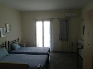 a bedroom with two beds and a large window at Serifos Palace in Livadakia