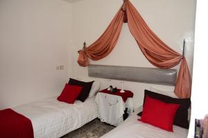 a bedroom with two beds with red pillows at Dar Amine in Rabat