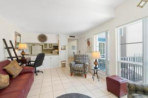 a living room with a couch and chairs and a kitchen at Madeira Beach Condo in St Pete Beach