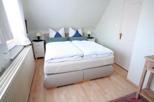 ザンクト・ペーター・オルディングにあるGästehaus Gorch-Fockのベッドルーム1室(青と白の枕が備わるベッド1台付)